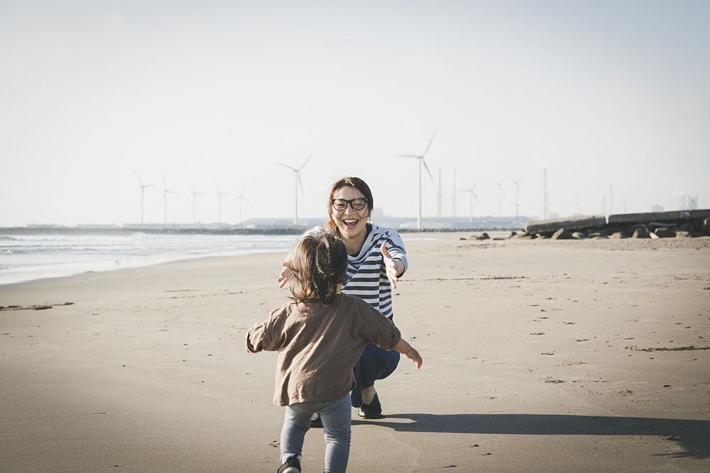 Ett barn springer till sin mamma på stranden